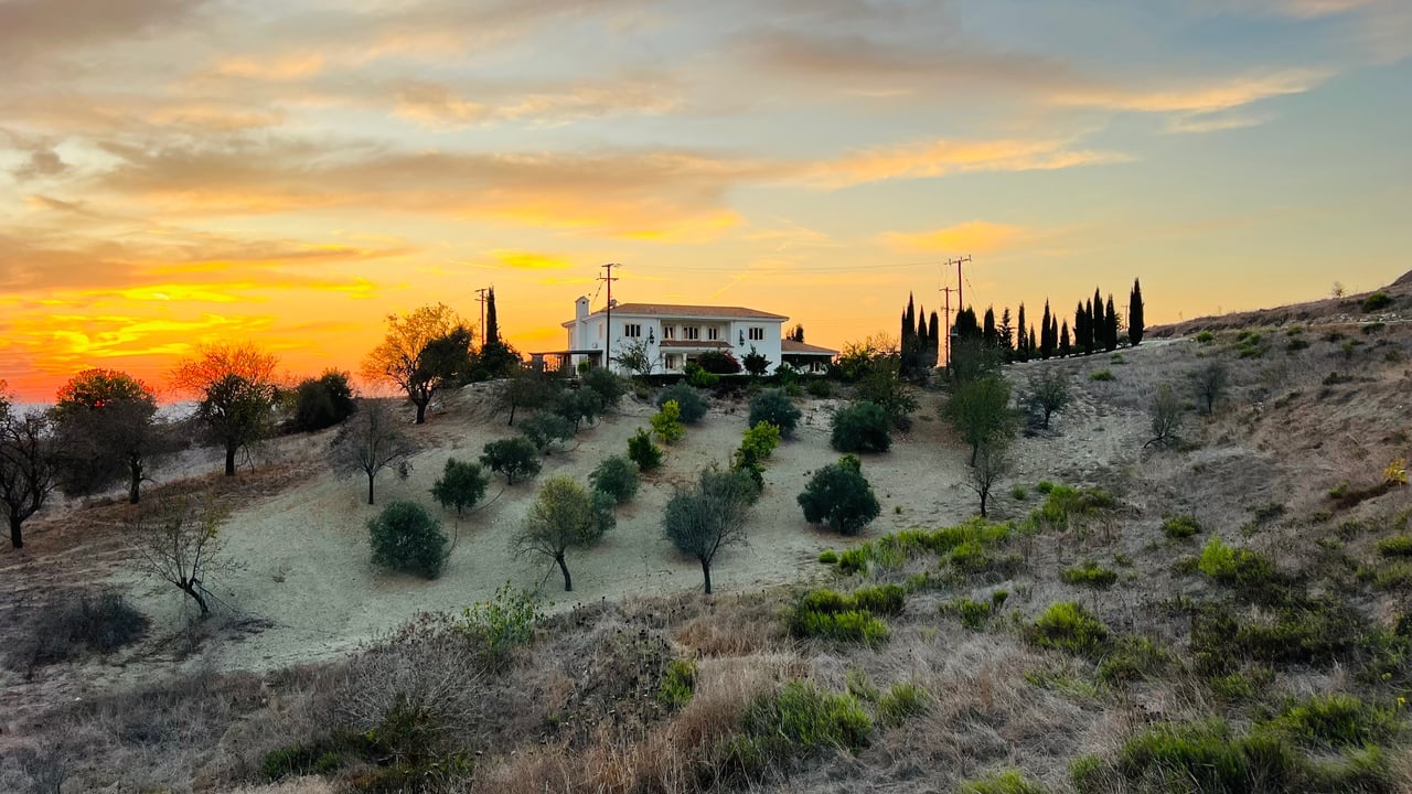 Villa Onassa on its hillside among olive trees at sunset